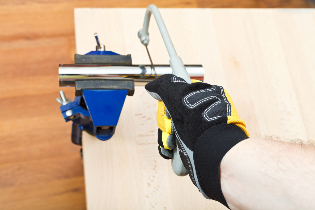 Plumber Sawing Plumbing Drain Pipe Gripped in Vice