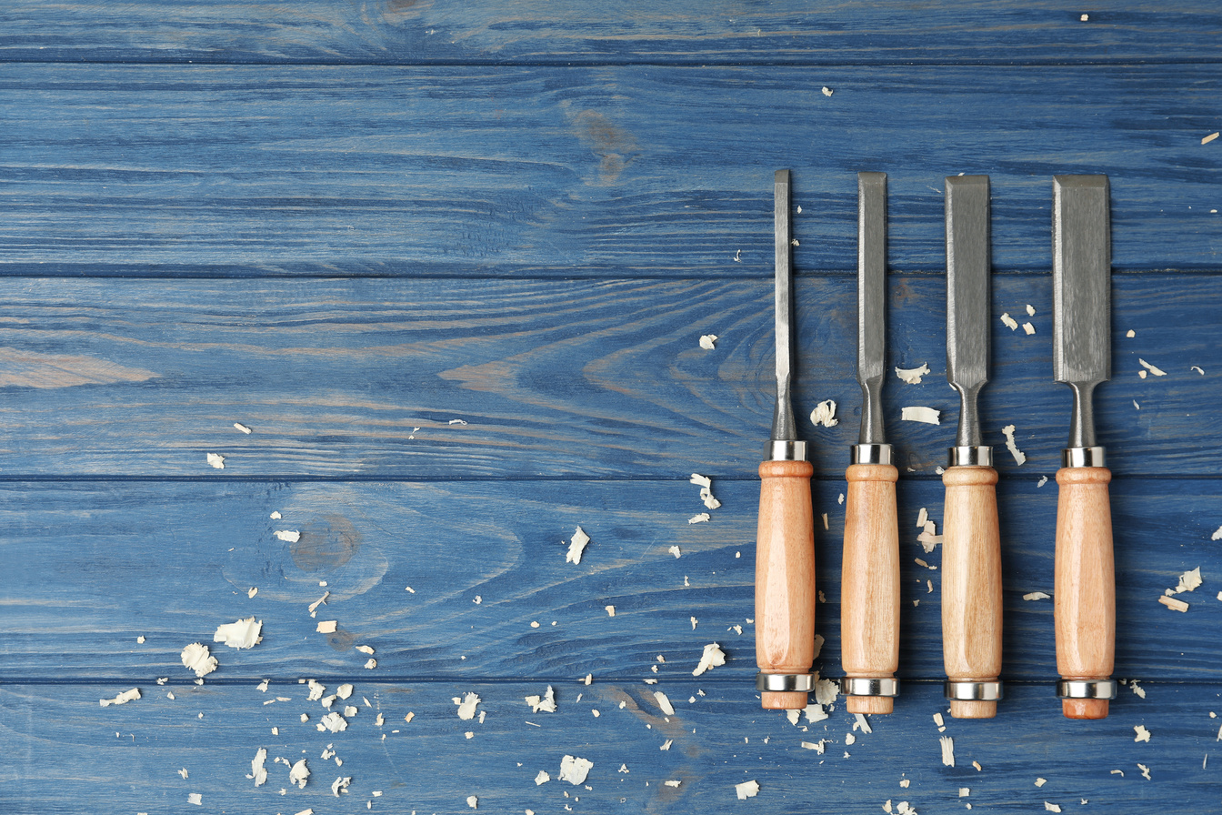 Modern Chisels on Blue Wooden Background, Flat Lay with Space for Text. Carpenter's Tools